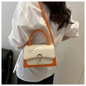 Detail of color-block bag with woven texture flap and horseshoe metal lock clasp