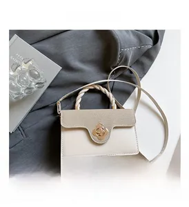 Detailed macro view of cream handbag featuring floral gold clasp and woven handle texture
