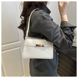 Detailed back view of white crocodile pattern shoulder bag worn by model in soft light