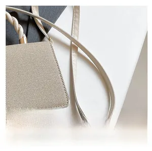 Detailed view of beige woven texture and stylish twisted handle on luxury crossbody bag