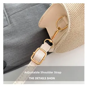 Detail of adjustable white leather strap and gold buckle on a woven beige crossbody bag