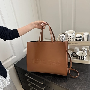 Minimalist large brown tote bag in matte synthetic leather with embossed lettering