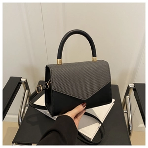 Détails du rabat gris à motifs géométriques et texture noire mate du sac à main