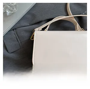 Detail of cream leather handbag with gold metal clasp and premium stitching on fabric