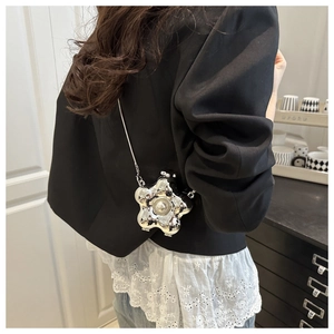 Detail der silbernen Metall-Abendtasche in Blumenform mit Perle und schmaler Kette