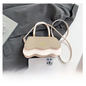 Size comparison of the off-white woven handbag with a smartphone on a grey blazer