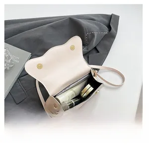 Interior view showing the capacity of a cream shoulder bag with items inside