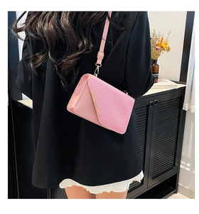 Sac à bandoulière rose avec élégantes finitions métalliques dorées et texture raffinée