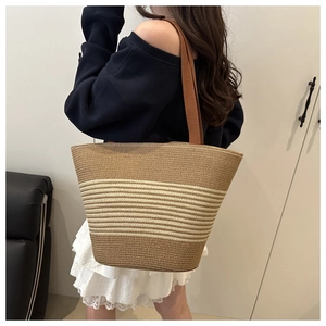 Model wearing a two-tone woven cotton rope tote bag with wide shoulder strap
