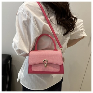 Detail of pink leather handbag with red and white checkered flap and golden metal buckle
