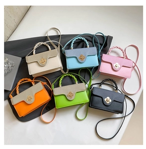 Flat lay of small crossbody bags in six vibrant colors with gold petal buckles