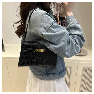 Detail of black crocodile embossed PU shoulder bag featuring elegant golden twist lock clasp