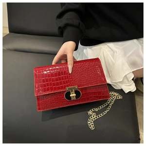 Macro detail of red crocodile embossed leather texture and golden T-shaped metal clasp