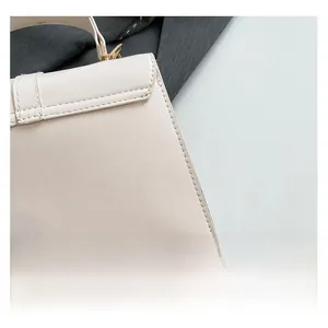 Primer plano de las costuras precisas y el cuero crema de alta calidad en el bolso de mujer