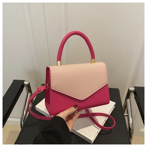 Détail d'un sac à main rose avec rabat tissé à chevrons beige et finitions dorées