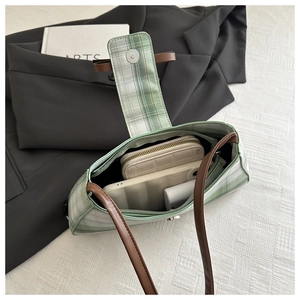 Internal view of green striped underarm bag showing capacity for phone and wallet