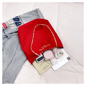 Flat lay of red canvas tote bag with woven handles and plaid lining for daily commute