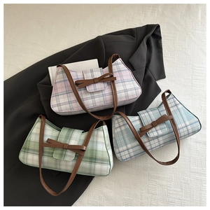 Close-up of three retro plaid baguette bags in pink, blue, and green with leather bows