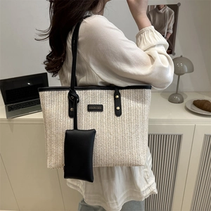 Chic beige and black woven straw tote bag with leather strap shown in daily commute use