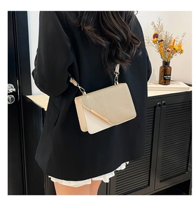 Detail of champagne gold textured crossbody bag with metallic trim and leather base