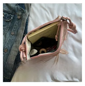 Sac fourre-tout rose en dentelle papillon montrant la capacité avec un carnet