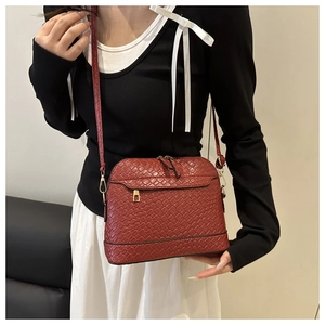 Détail du sac à main rouge foncé en cuir tressé avec des finitions métalliques dorées