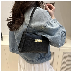 Detail view of black quilted faux leather crossbody bag with elegant gold metal lock