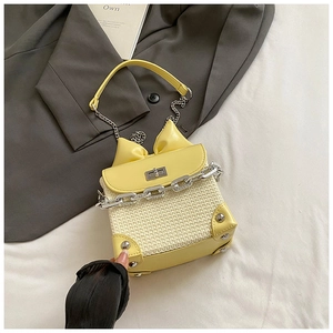Detail of woven chain bag with yellow leather bow, silver rivets and metal clasp