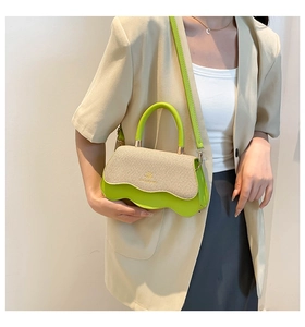 Detail view of the lime green leather base with wavy edges and beige tweed flap on the handbag