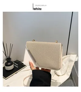 Détail du sac bandoulière blanc avec rabat texturé et garniture métallique élégante