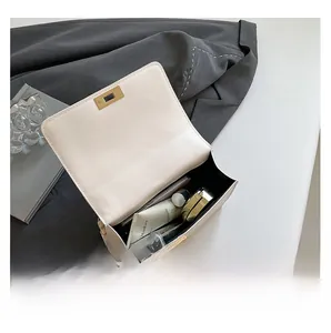 Interior view of beige leather chain bag showing capacity for phone and cosmetics