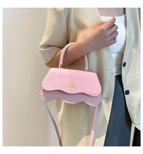 Detail of pink patchwork crossbody bag featuring gold logo and wave edge texture