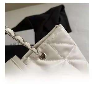 Detail of silver chain strap through eyelets on white quilted leather tote bag