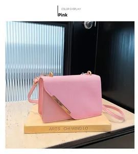 Détail du sac bandoulière rose montrant la texture d'épissage et la barre dorée
