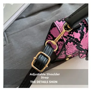 Detail of snake print crossbody bag with adjustable black leather strap and gold buckle
