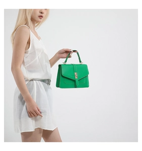 Detalle del bolso bandolera verde con vista lateral, textura de cuero mate y cierre dorado