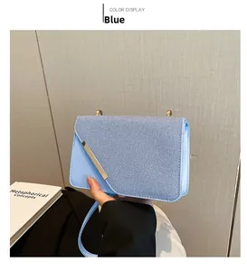 Détail d'un sac bandoulière bleu clair avec tissu sergé et finitions en métal doré