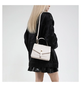 Bolso bandolera de cuero blanco crema con un clásico cierre giratorio de metal dorado