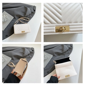 Detail view of white chevron quilted handbag with gold hardware and chain strap