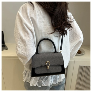 Detail of color-block handbag with gray twill texture and gold horseshoe buckle