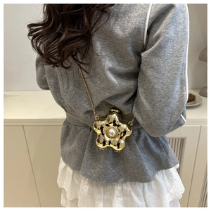 Detailansicht der goldene Mini-Umhängetasche in Blumenform mit Perle und Metallkette