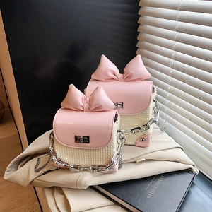 Pink bow straw shoulder bag with chain strap and contrast design for summer 2025