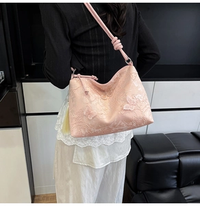 Detailed pink shoulder bag featuring 3D butterfly embroidery and yellow tassel charm