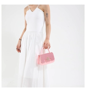 Close-up of pink crossbody bag with sparkling sequin flap and gold logo detail