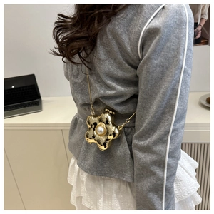 Detailansicht der goldenen Blumen-Mini-Umhängetasche mit Perle und feiner Metallkette