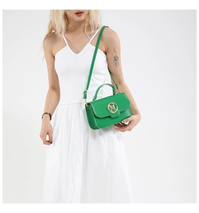 Detail of bright green crossbody bag with golden M metal logo and adjustable strap