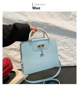 Detail of light blue crocodile pattern crossbody bag with golden deer charm and metal handle