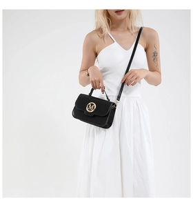 Close-up of black leather crossbody bag featuring a prominent gold metal M letter logo