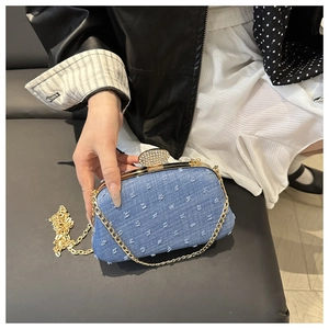 Close-up of denim evening bag with fringe polka dots and rhinestone metal clasp