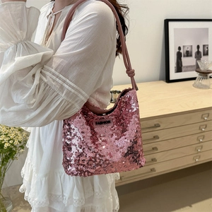 Chic sac hobo rose à paillettes pour femme porté par un mannequin dans un intérieur